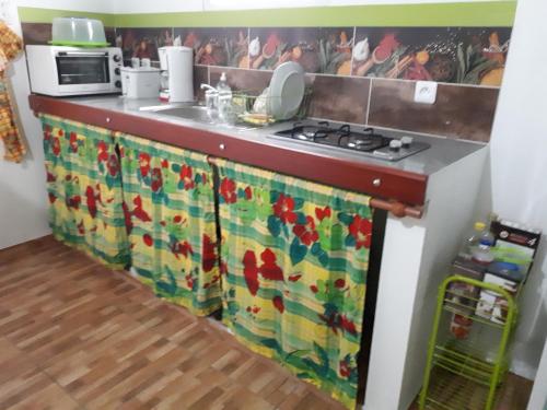 a kitchen with a counter with a sink and a stove at La Casa Binecha avec Jacuzzi in Baillif
