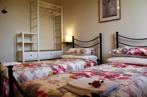 a bedroom with two beds and a mirror at Le Case in Bevagna