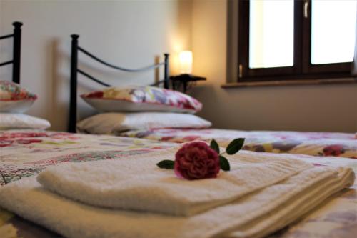 two beds with towels and a rose on them at Le Case in Bevagna