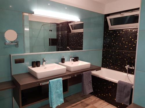 ゼーボーデンにあるSPA-Loungeのバスルーム(シンク2台、鏡、バスタブ付)