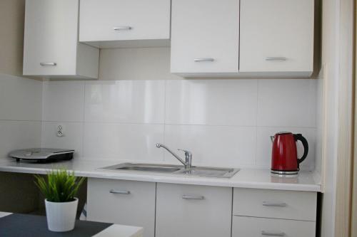 a kitchen with white cabinets and a red appliance at Jas in Jastarnia