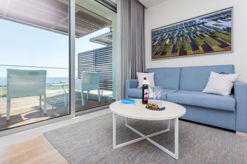 a living room with a blue couch and a table at Palmares Beach House Hotel - Adults Friendly in Lagos
