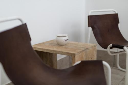a small table with a cup on it next to two chairs at Love & Fama Hotel in Sabaudia
