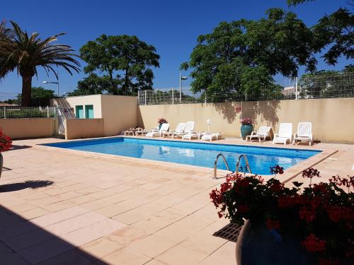 une piscine avec des chaises longues et une piscine dans l'établissement 2 rue Raffanel, au Cap d'Agde