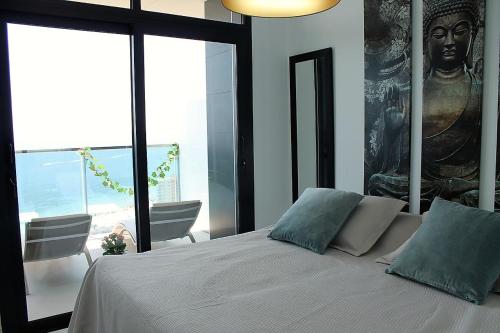 ベニドルムにあるSunset Drive Sea Views Apartmentのベッドルーム1室(大きな絵画が壁に描かれたベッド1台付)