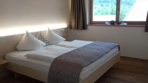 a bedroom with a bed with pillows and a window at Bauernhof Residence Hausergut with Ortler views, central and quiet position in Sluderno