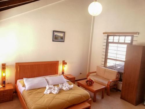 Un dormitorio con una cama con toallas blancas. en Hotel La Primavera, en Riobamba