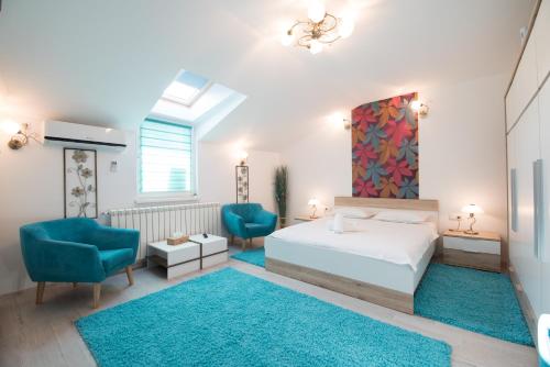 - une chambre avec un lit et deux chaises bleues dans l'établissement Queen Holiday Apartment, à Bucarest