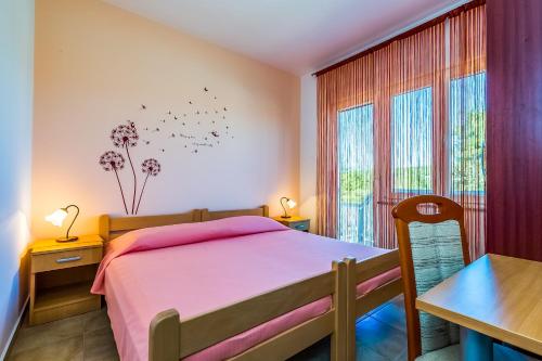 a bedroom with a bed and a table and a window at Apartman - The view in Krk