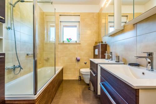 a bathroom with a tub and a sink and a toilet at Apartman - The view in Krk