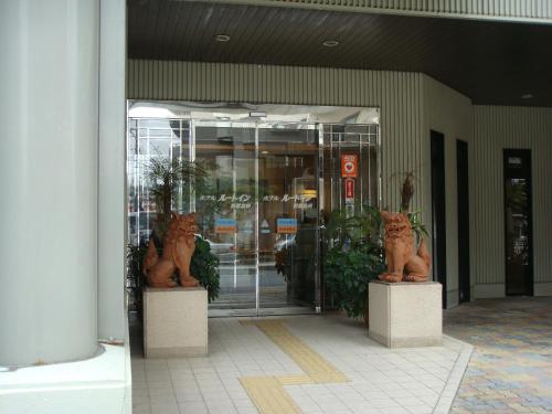 una entrada a un edificio con dos estatuas de gatos en Hotel Route-Inn Naha Asahibashi Eki Higashi, en Naha