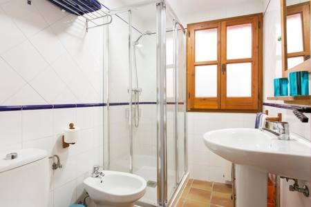 y baño con ducha, aseo y lavamanos. en Luminous Alhambra view apartment in Albayzín, en Granada