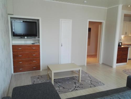 a living room with a tv on a white wall at Anna Apartment in Pori