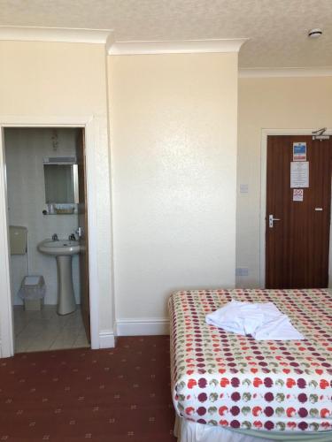 a hotel room with a bed and a bathroom at Hotel Athol Blackpool in Blackpool