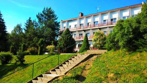 a building on a hill with stairs in front of it at Osrodek Wypoczynkowy " BIESZCZADY" in Myczkowce