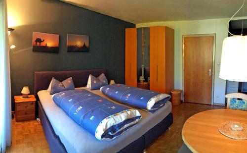 Bett mit blauen Kissen auf einem Zimmer in der Unterkunft Ferienwohnung Brigitte in Schruns-Tschagguns