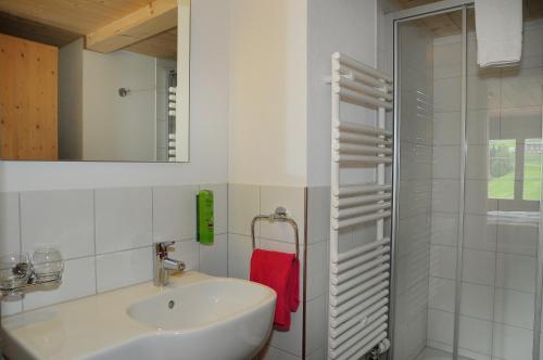 uma casa de banho branca com um lavatório e um chuveiro em Berggasthaus Gemsli em Sankt Antönien