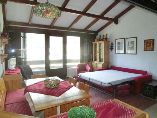 Habitación con cama, mesa y sillas. en Bilocale Alberti - Silvana, en Madonna di Campiglio