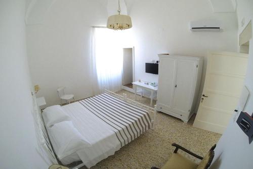 a bedroom with a bed and a cabinet and a window at B&B PALAZZO MARZO in Otranto
