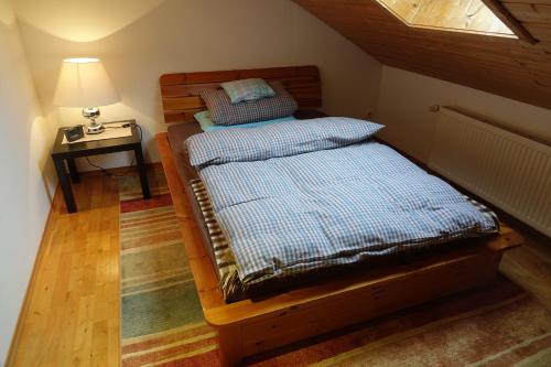 two beds in a room with a lamp and a table at Haus Riegseeblick in Riegsee