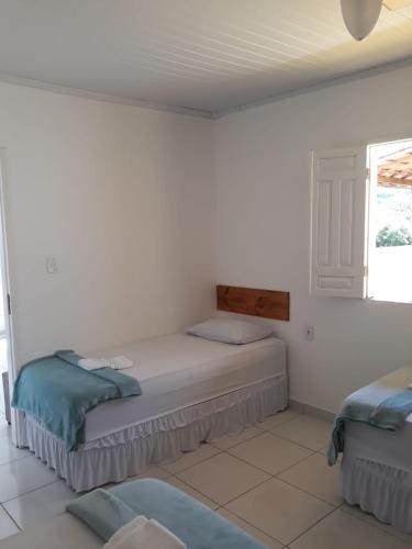 a bedroom with two beds and a window at O Pouso Condomínio in Mucugê