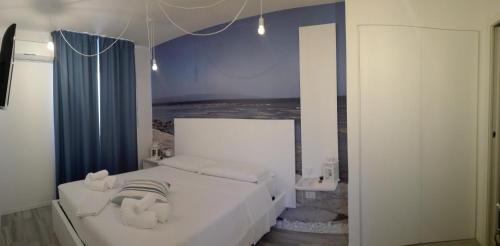 Un dormitorio con una cama blanca con toallas. en Lyria, en Marzamemi
