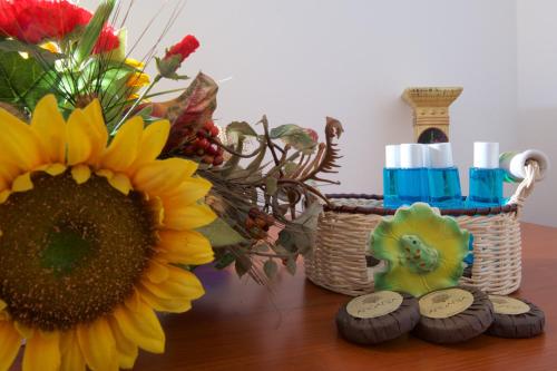 a table with a sunflower and a basket of flowers at B&B NiloSira in Morciano di Leuca