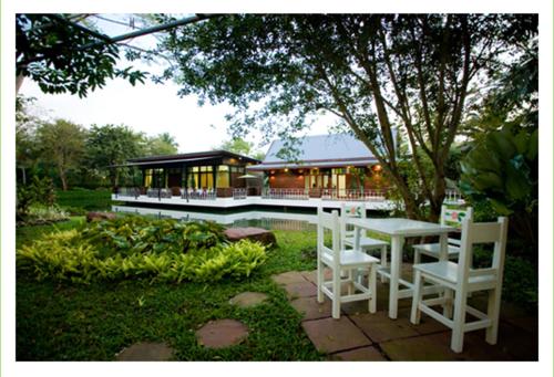 a table and chairs in front of a building at Young Coconut Garden Home Resort in Amphawa