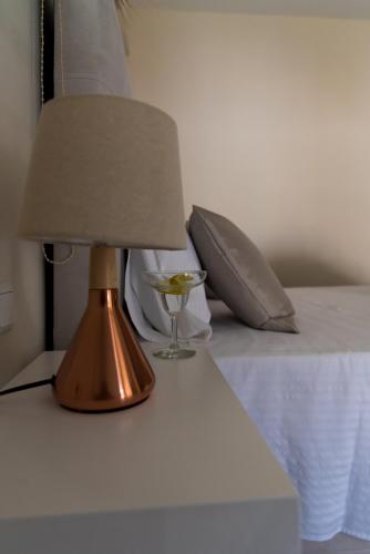 a lamp sitting on a table next to a bed at Kiperi Exclusive in Parga