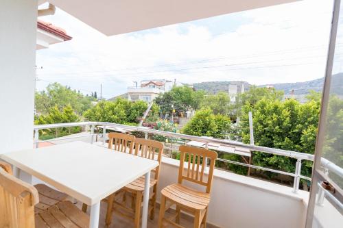 ein Balkon mit einem weißen Tisch und Stühlen in der Unterkunft Gebora Suits & Tatil Evleri in Palamutbükü