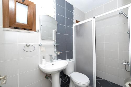 ein Badezimmer mit Waschbecken, Toilette und Spiegel in der Unterkunft Gebora Suits & Tatil Evleri in Palamutbükü