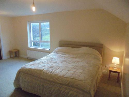 a bedroom with a bed and a window at Applewood Heights in Glenariff