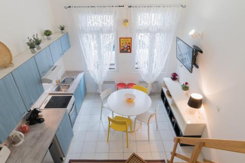 une petite cuisine avec une table blanche et des chaises jaunes dans l'établissement Yellow Submarine, à Montpellier