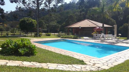 a swimming pool in a yard with a gazebo at Pousada Ribeirão do Ouro in Itamonte