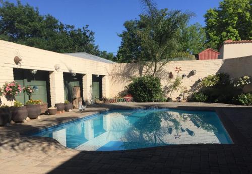 a swimming pool in front of a house at Welcome Guest House in Vereeniging
