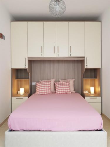 a bedroom with a large bed with white cabinets and pink pillows at L&G's Roof Terrace in Pisa