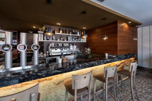 a bar with chairs and a counter in a restaurant at Apartamentos VIDA Mar de Laxe in Laxe