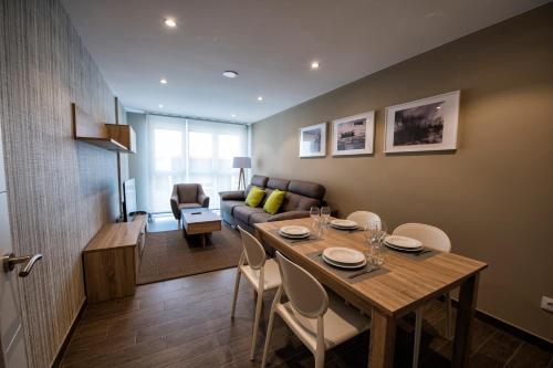 a living room with a table and a couch at Apartamentos VIDA Mar de Laxe in Laxe