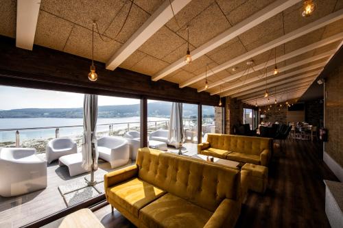 a living room with couches and a large window at Apartamentos VIDA Mar de Laxe in Laxe