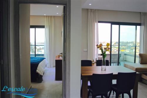 a living room with a dining room table and a bedroom at L'escale Suites Résidence Hôtelière By 7AV HOTELS in Mohammedia