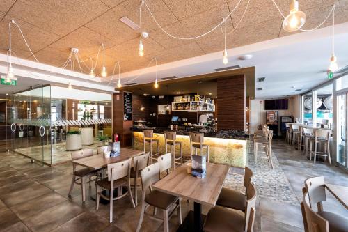 un restaurante con mesas y sillas y un bar en Hotel VIDA Mar de Laxe, en Laxe