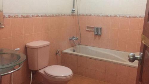 a bathroom with a toilet and a bath tub at Villa Bukit Punclut in Bandung