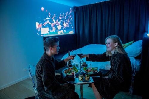 a man and woman sitting at a table with food and wine at Exclusieve privé wellness penthouse SkyNooz in Antwerp