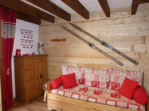 a room with a bed with red pillows at CAP DES NEIGES 1 in Barcelonnette