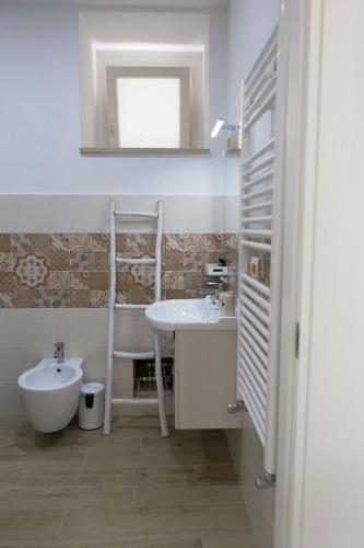 a bathroom with a sink and a toilet and a mirror at Vento di Sicilia in Siracusa