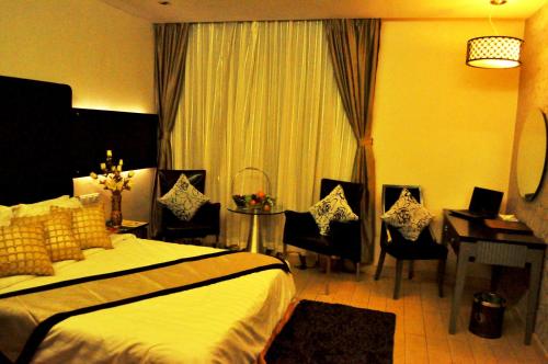 a hotel room with a bed and a table and chairs at Shervinton Executive Boutique Hotel in Tawau
