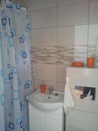 a bathroom with a sink and a shower curtain at MAXI - Mielenko in Mielenko