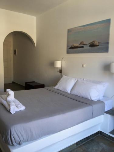 a bedroom with a bed with a teddy bear on it at Pasithea Folegandros in Agali