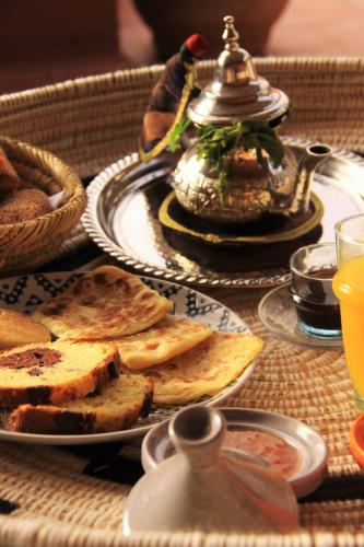 - une table avec des assiettes de nourriture et une bouilloire dans l'établissement Riad Miski, à Marrakech