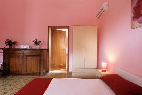 a bedroom with pink walls and a bed and a door at Villa Mele in Lido Marini